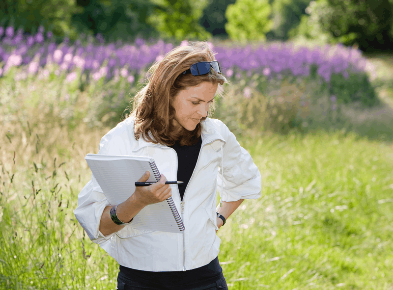 Rachel Ellison - standing in a field with notepad